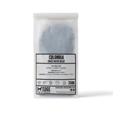 Coffee package labeled 'Colombia Swiss Water Decaf' by Edge Tea & Coffee on a white background